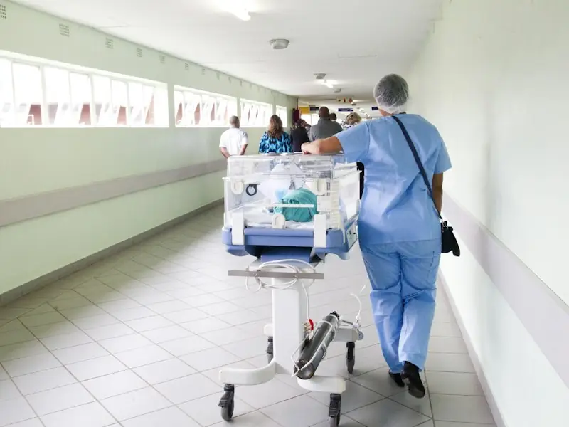 Healthcare professional in scrubs walking a hospital corridor
